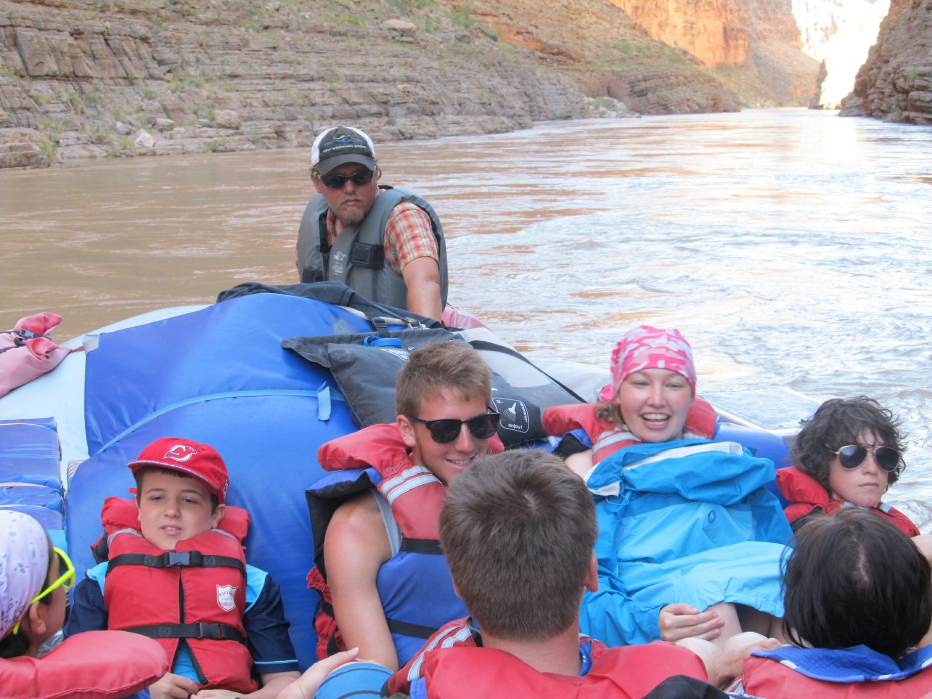 A group of people in life jackets are floating down a river