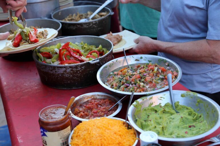 A table full of bowls of food including guacamole and salsa