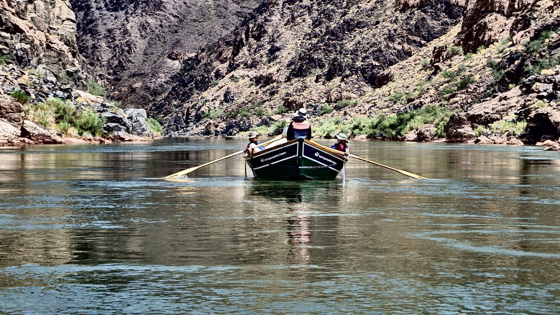 A boat is floating on a river with mountains in the background