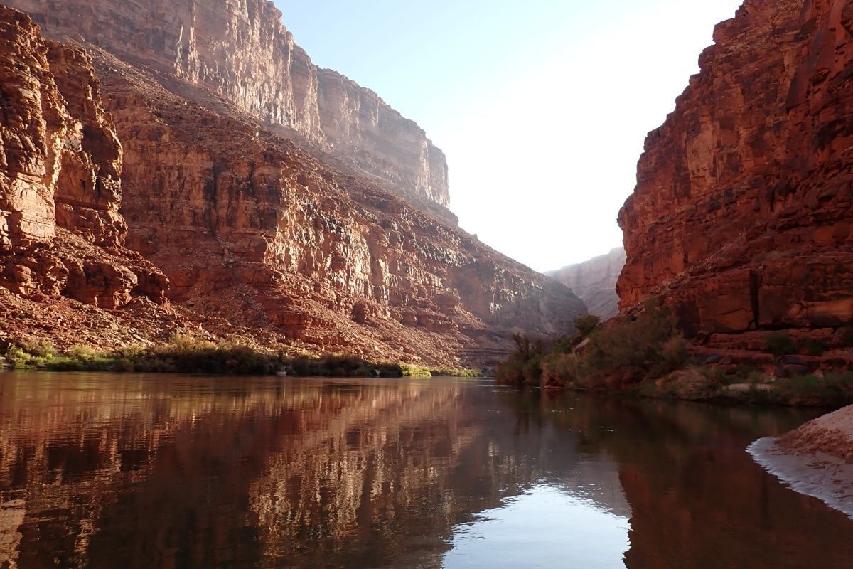 A river flowing through a canyon with mountains in the background