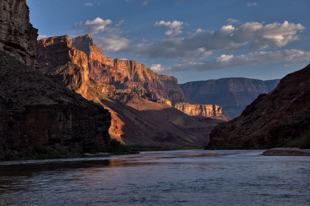 A river flowing through a canyon with mountains in the background