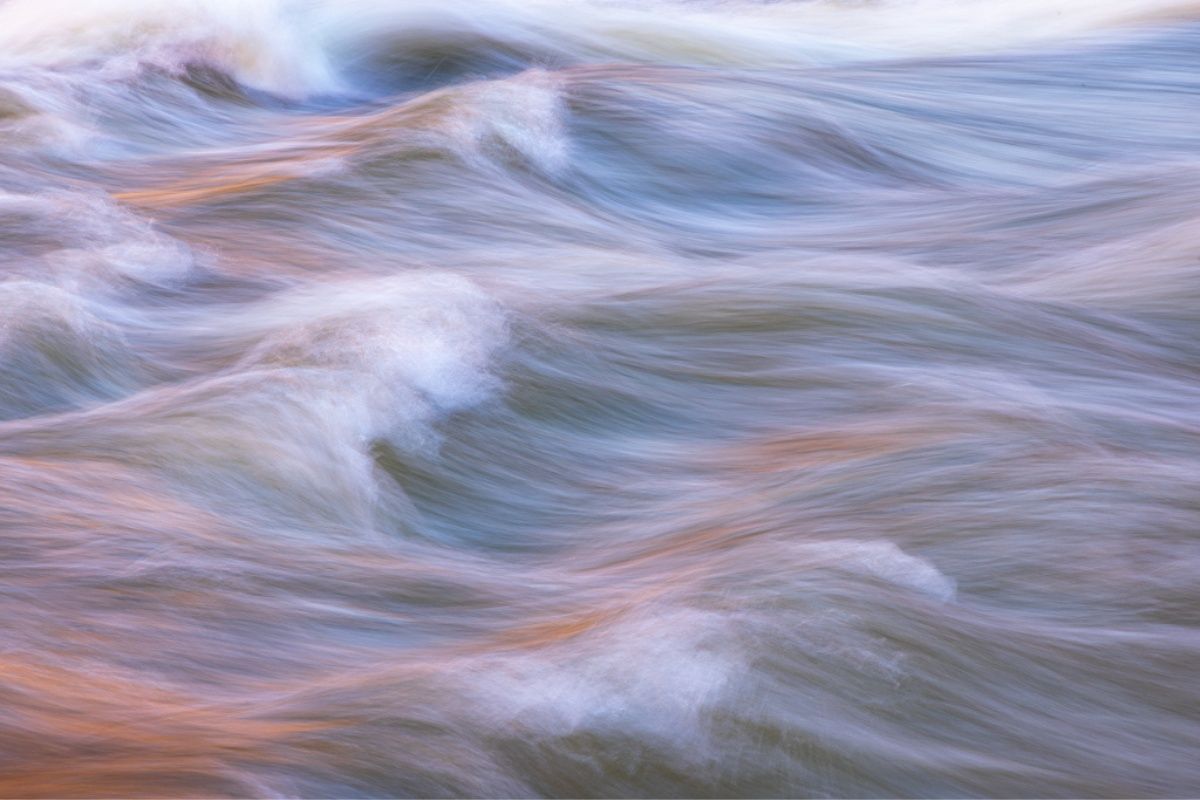 A close up of a river with waves coming in and out of it.