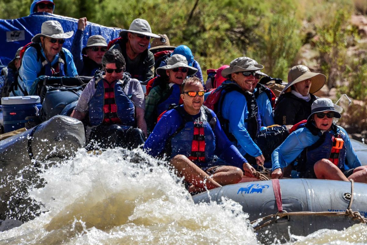 A group of people are rafting down a river in a pelican raft