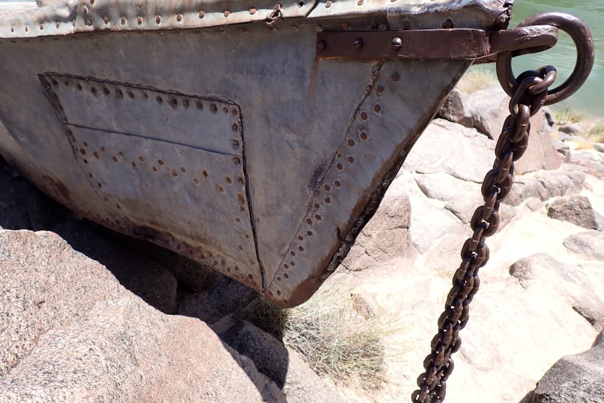 A boat is tied to the rocks with a chain