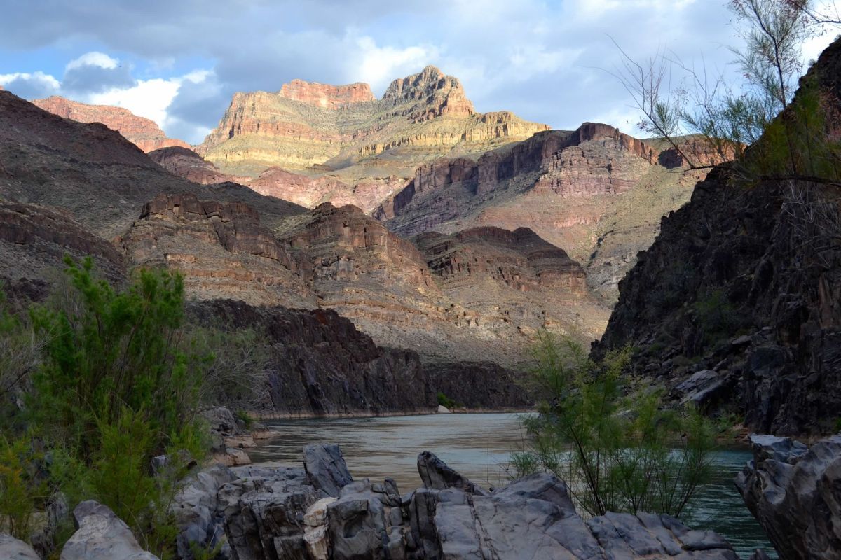 A river runs through a canyon with mountains in the background