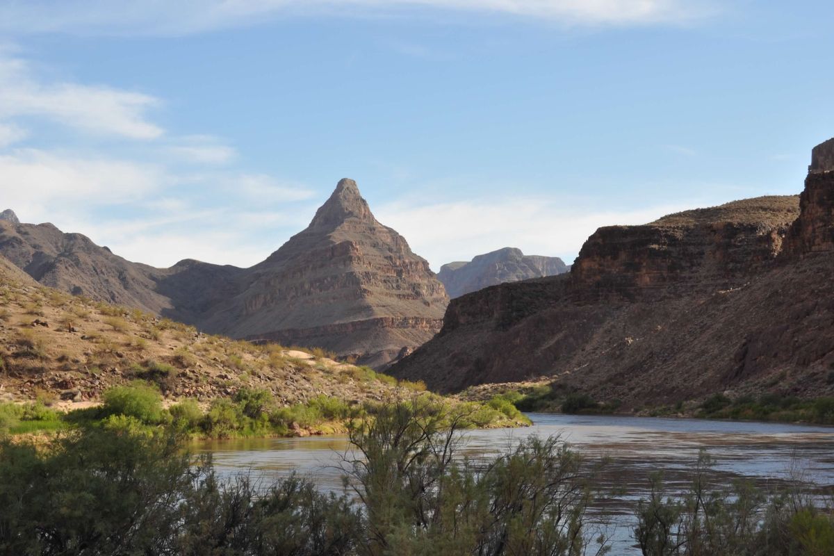 A river runs through a canyon with mountains in the background