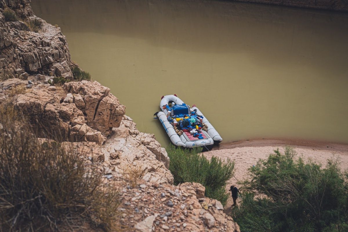 A raft is sitting on the shore of a river.