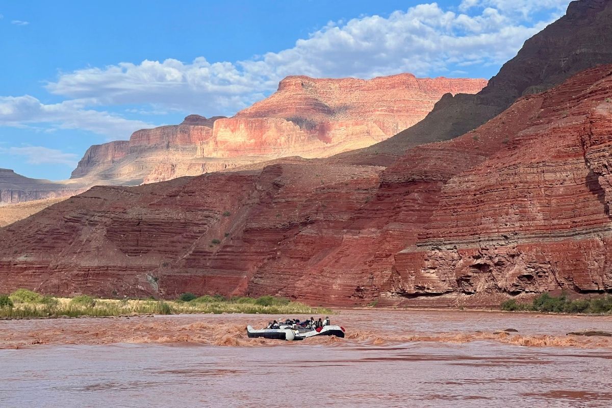 A river with mountains in the background and a truck in the foreground