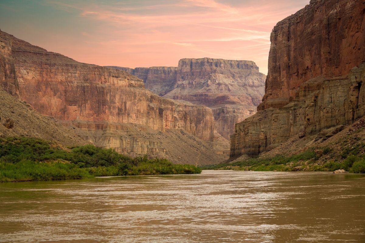A river flowing through a canyon with mountains in the background.