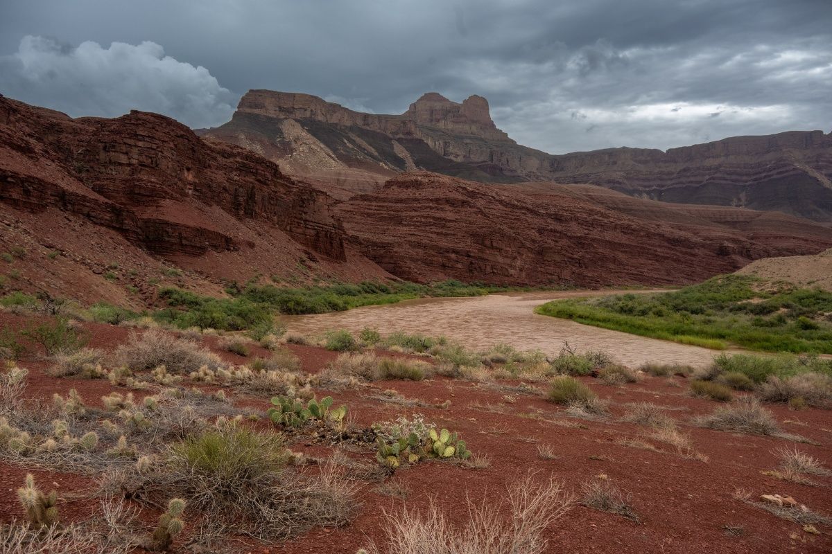 A desert landscape with mountains in the background and a river in the foreground.