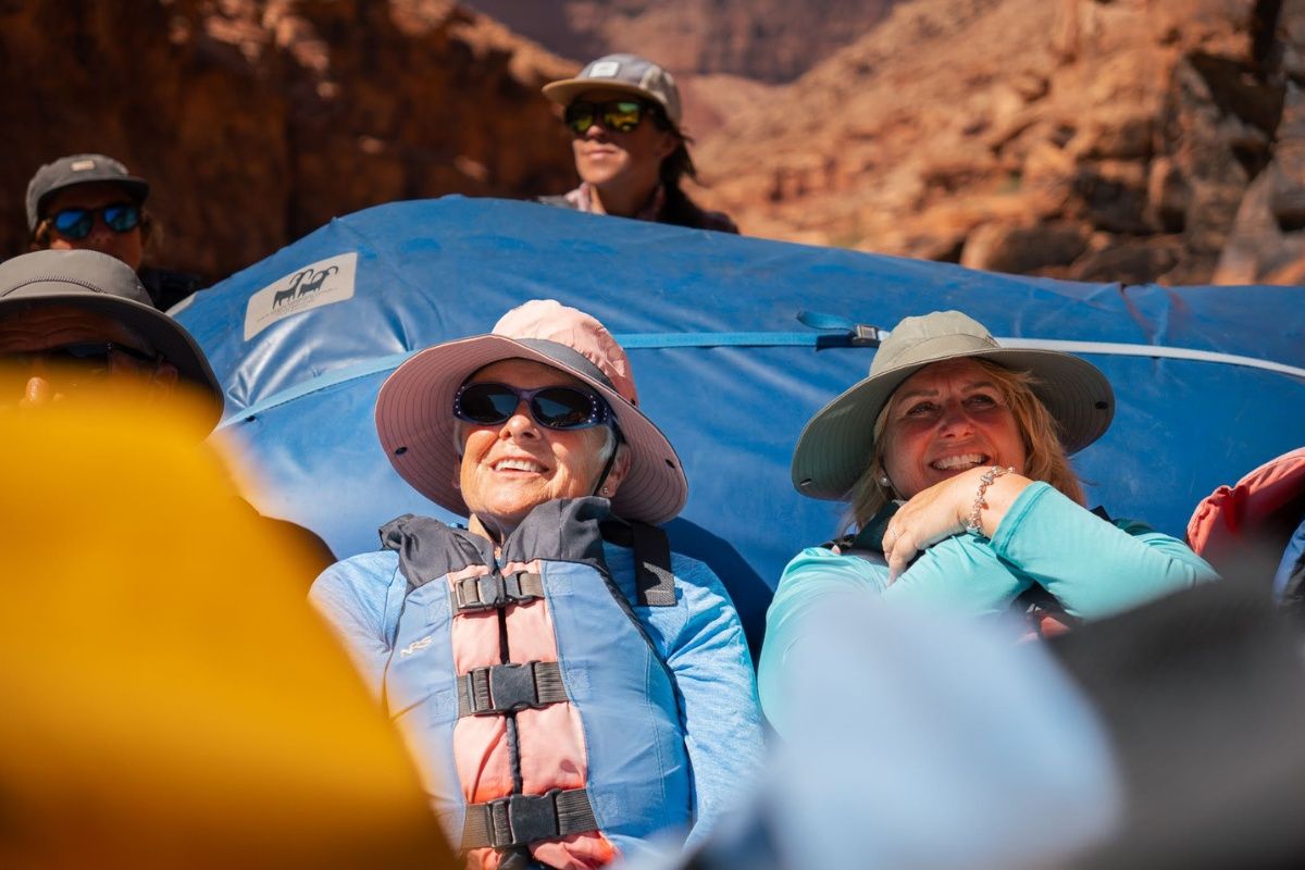 A group of people are sitting in a boat on a river.