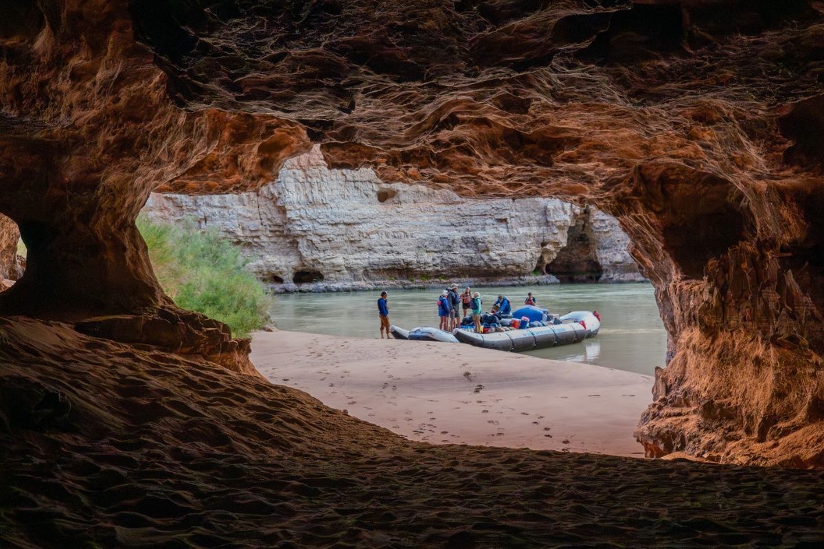 A group of people are rafting down a river in a cave.
