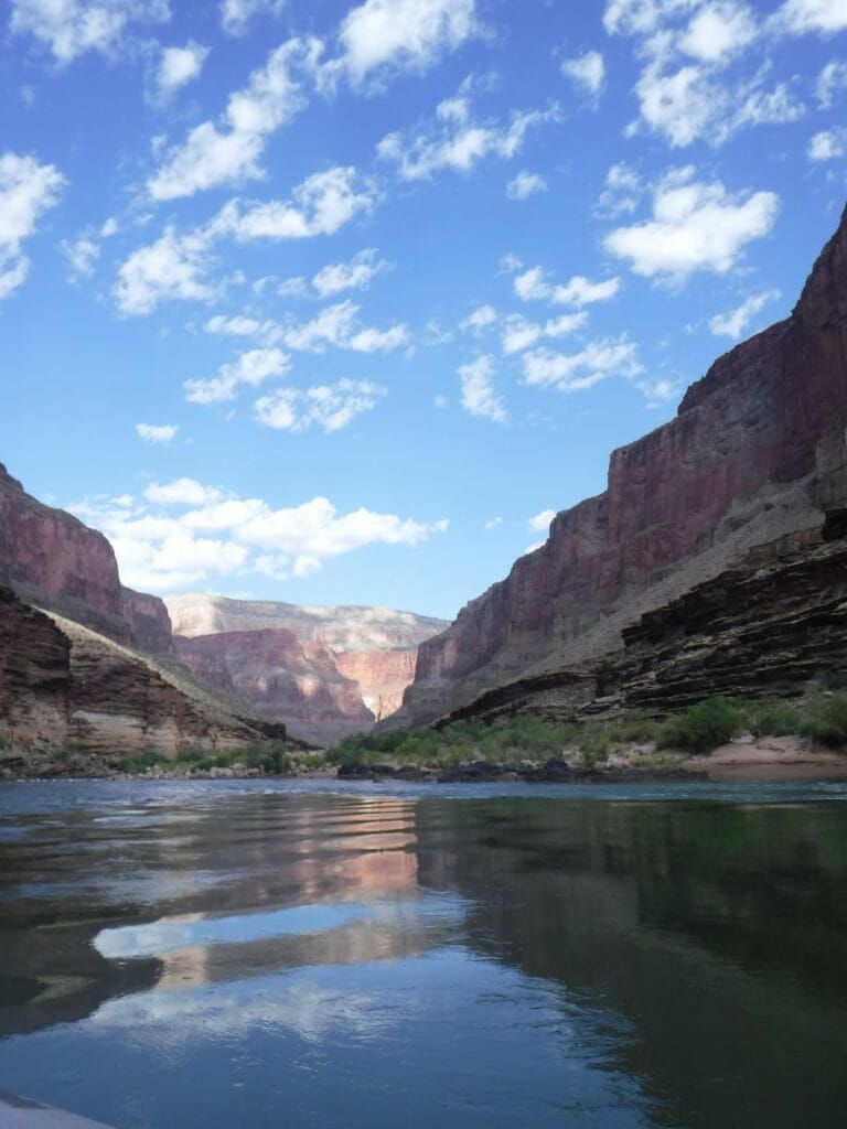 A river flowing through a canyon with mountains in the background