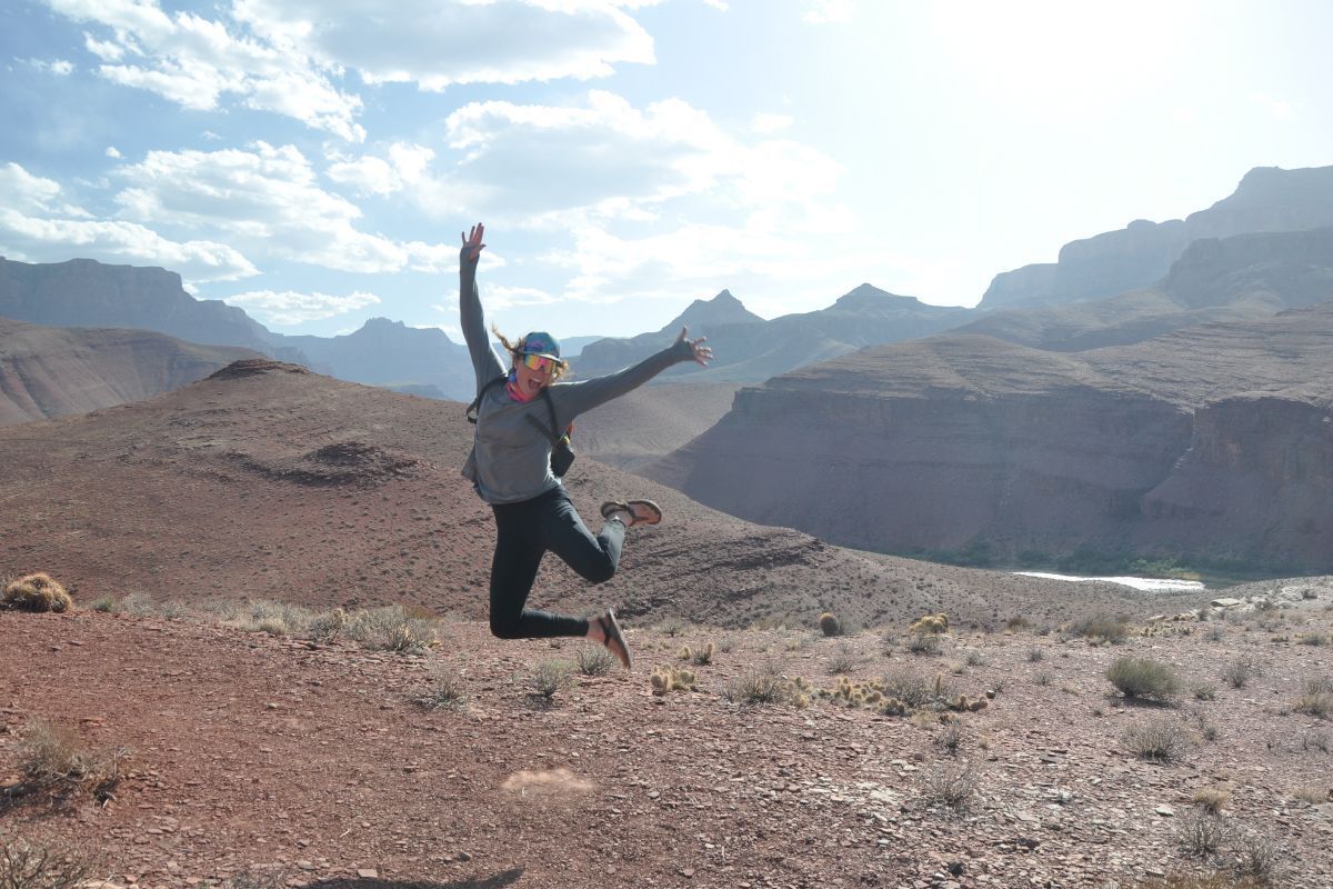 A person jumping in the air with mountains in the background