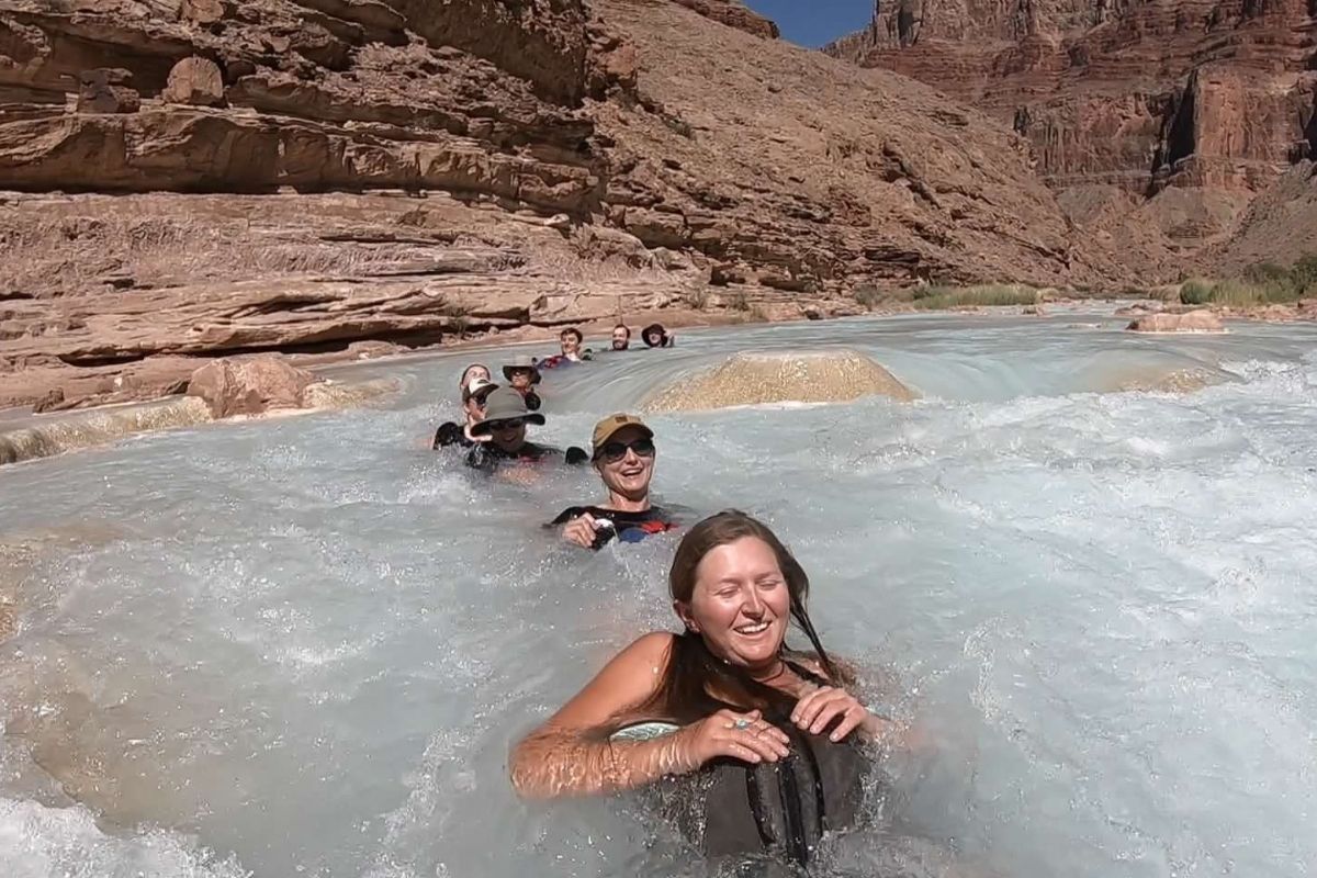 A group of people are swimming in a river