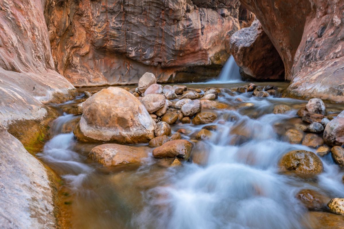 A river flowing through a rocky canyon with a waterfall
