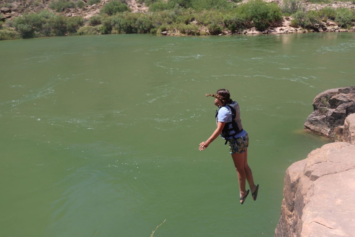 A woman is jumping into a body of water