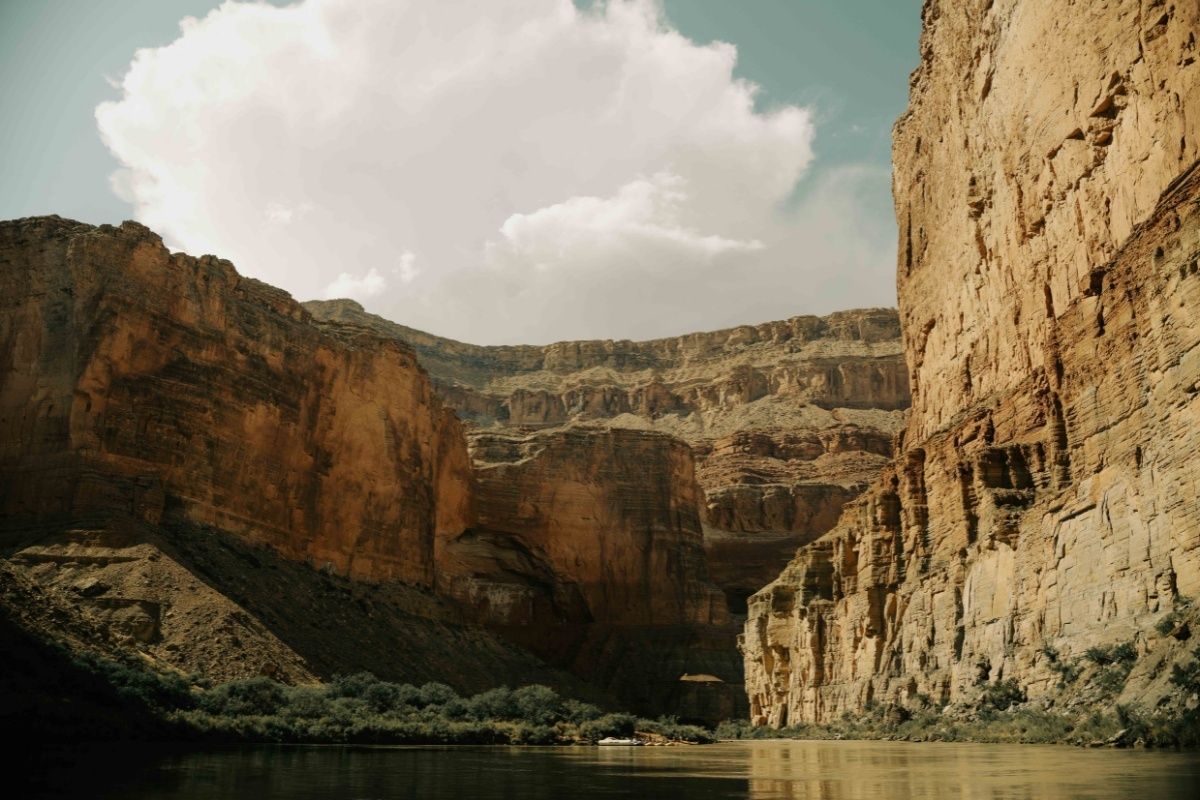 A river flowing through a canyon with mountains in the background.