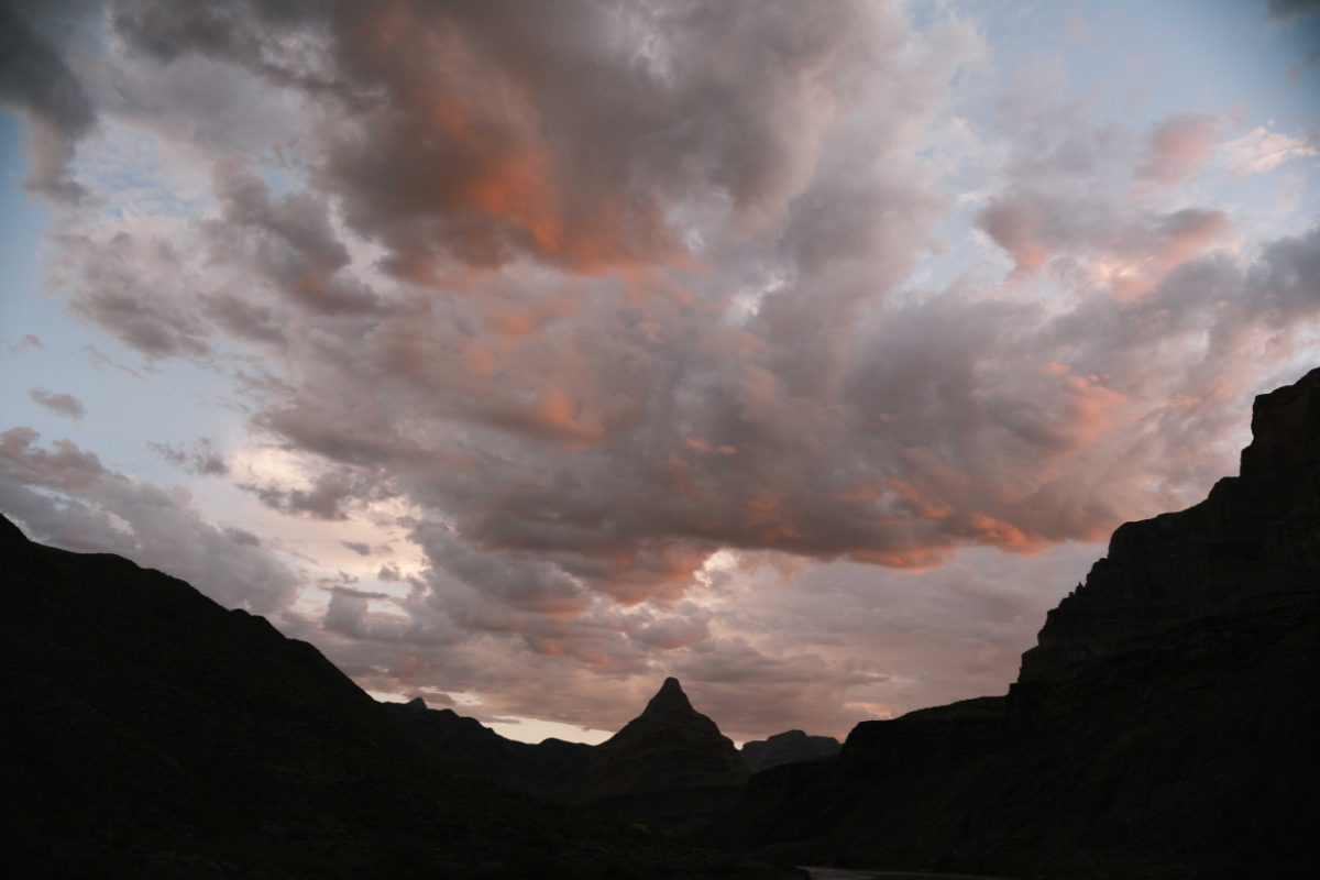 A mountain silhouetted against a cloudy sky at sunset
