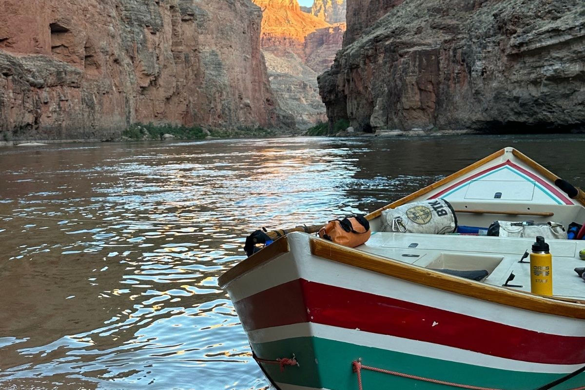A boat is floating on a river in a canyon.