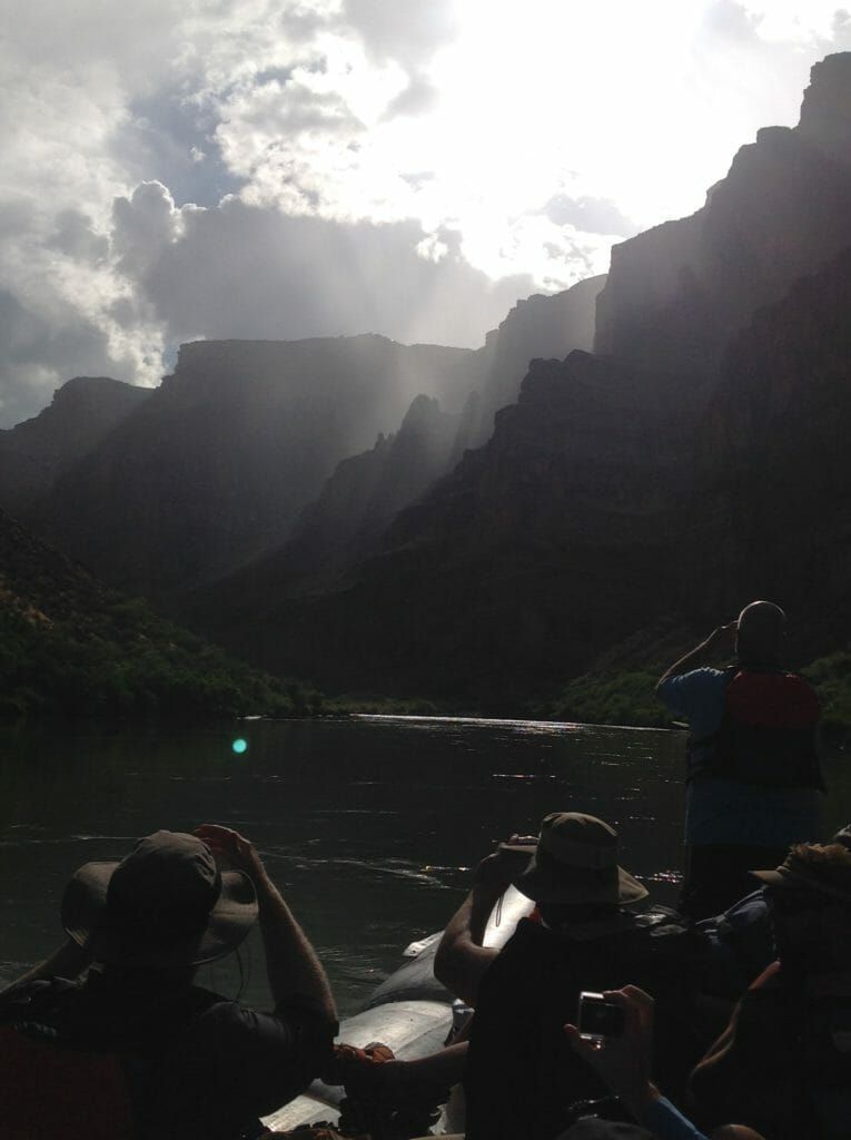 A group of people in a boat with mountains in the background