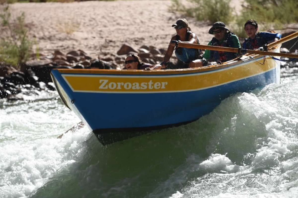 A blue and yellow boat with the name zoroaster on it