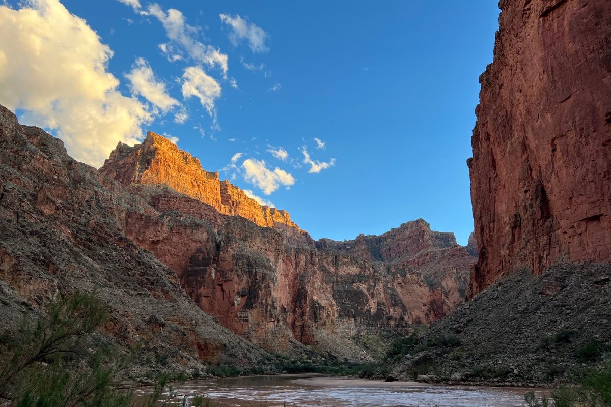 A river running through a canyon with mountains in the background