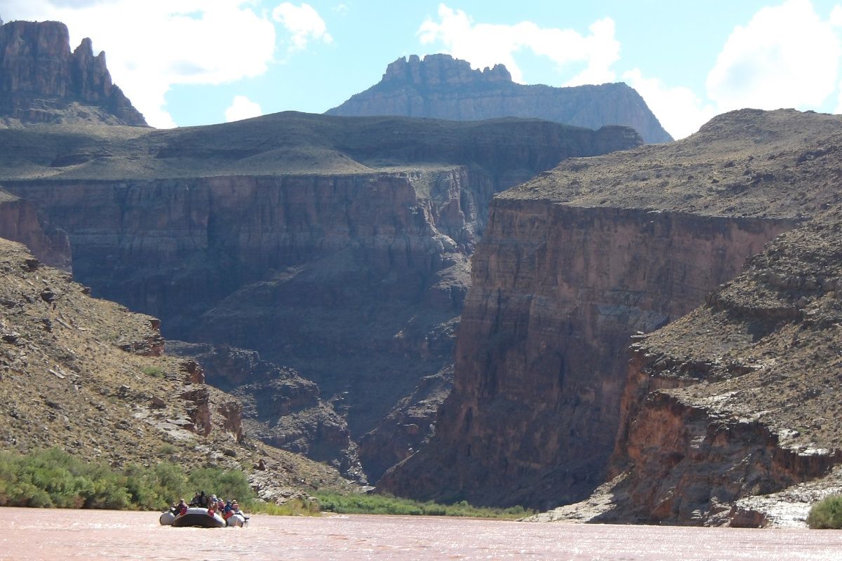 A river with mountains in the background and a boat in the foreground