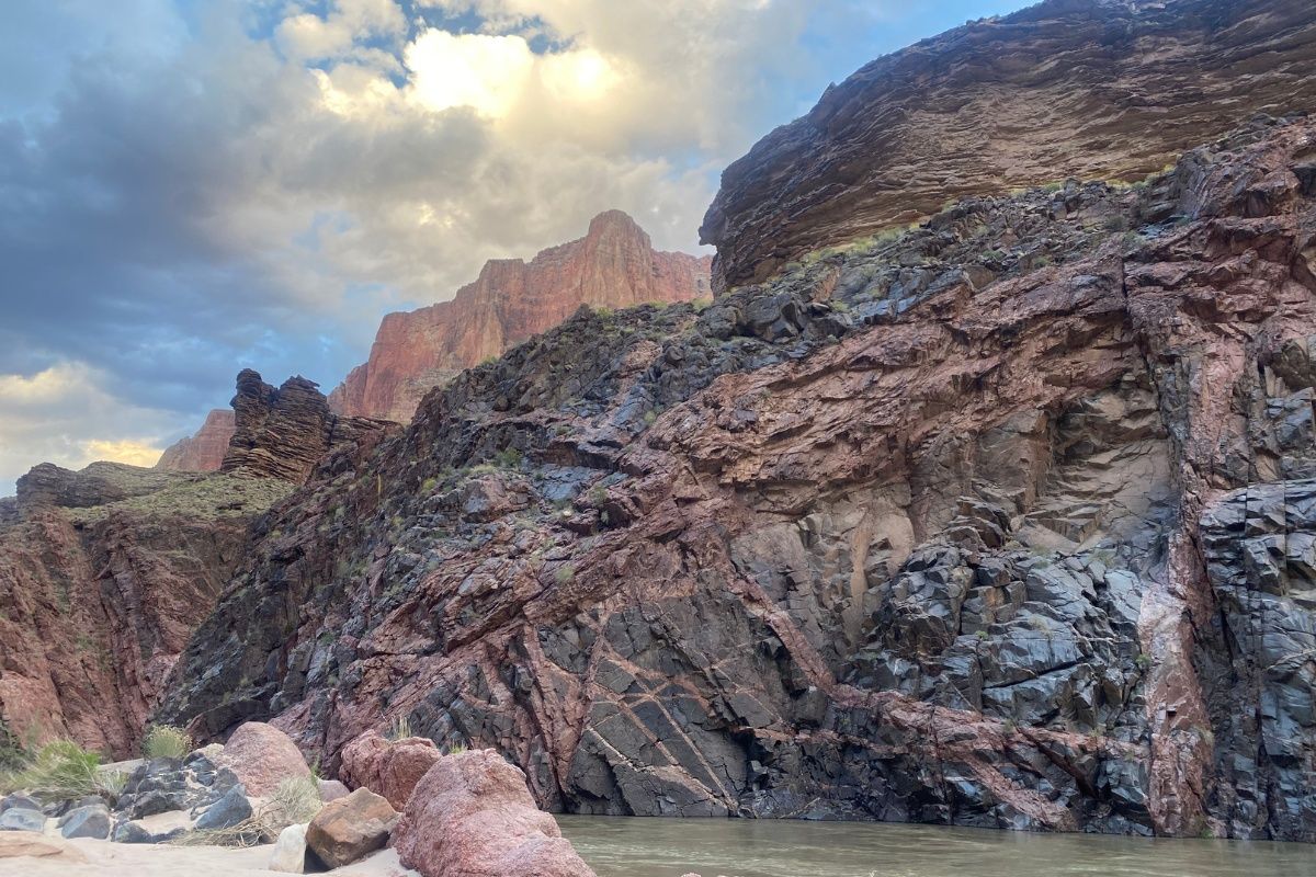 A river runs through a canyon with a mountain in the background.