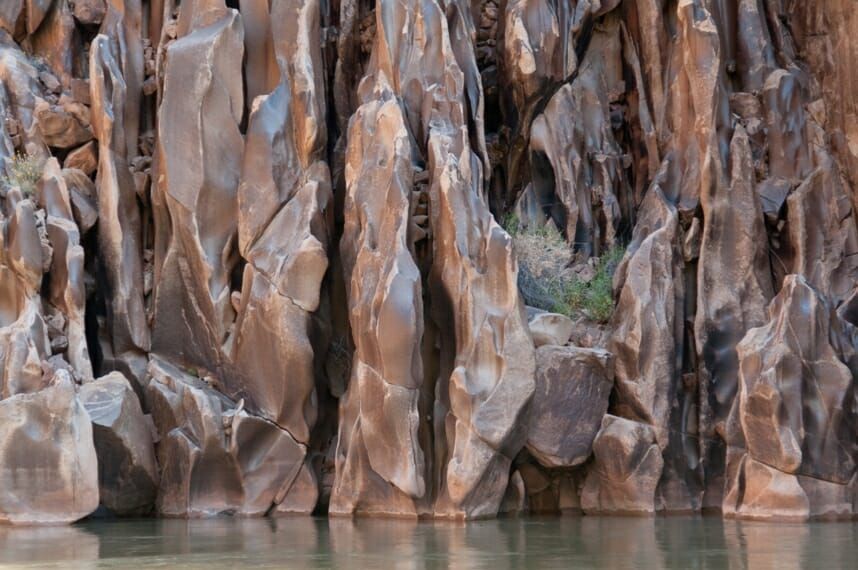 A large rock wall surrounds a body of water.