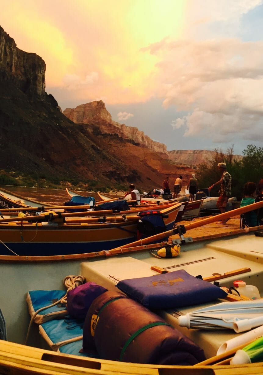 A group of boats are sitting on the shore of a river.