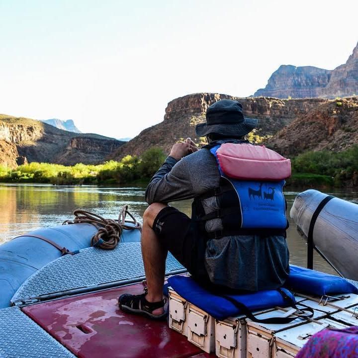 A man in a life vest is sitting on a boat