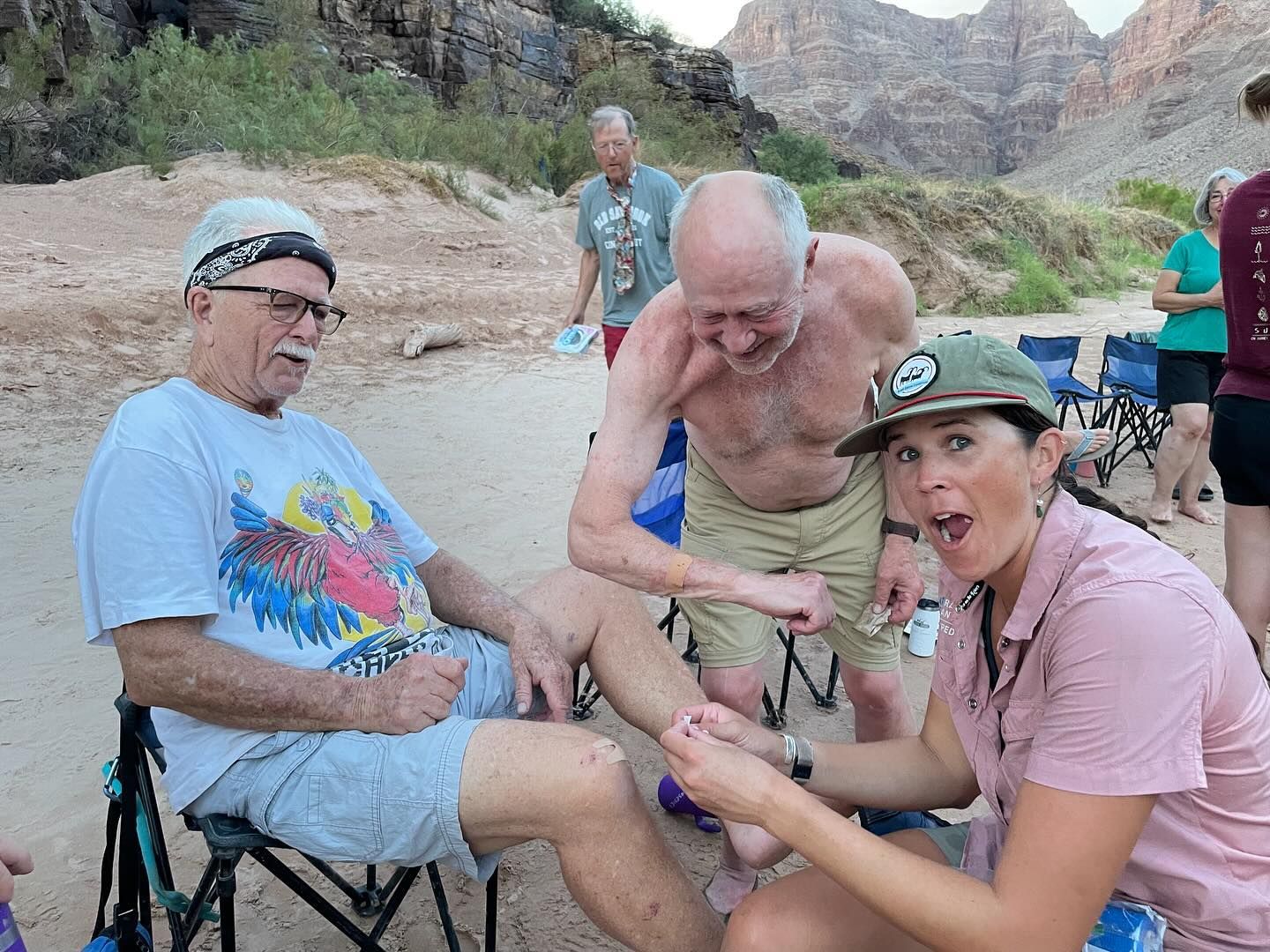 A group of people are sitting around a man 's leg.