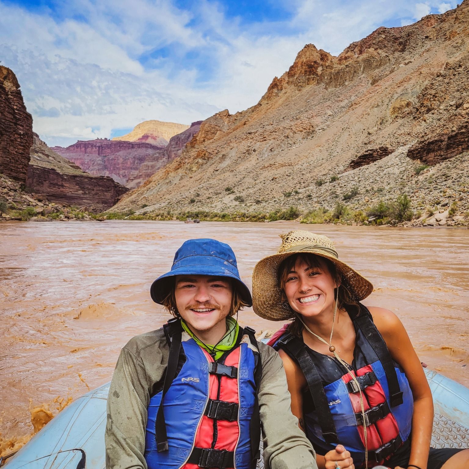 A man and a woman are sitting in a raft on a river