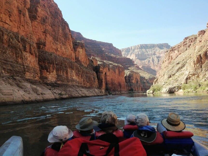 A group of people are on a boat in a canyon
