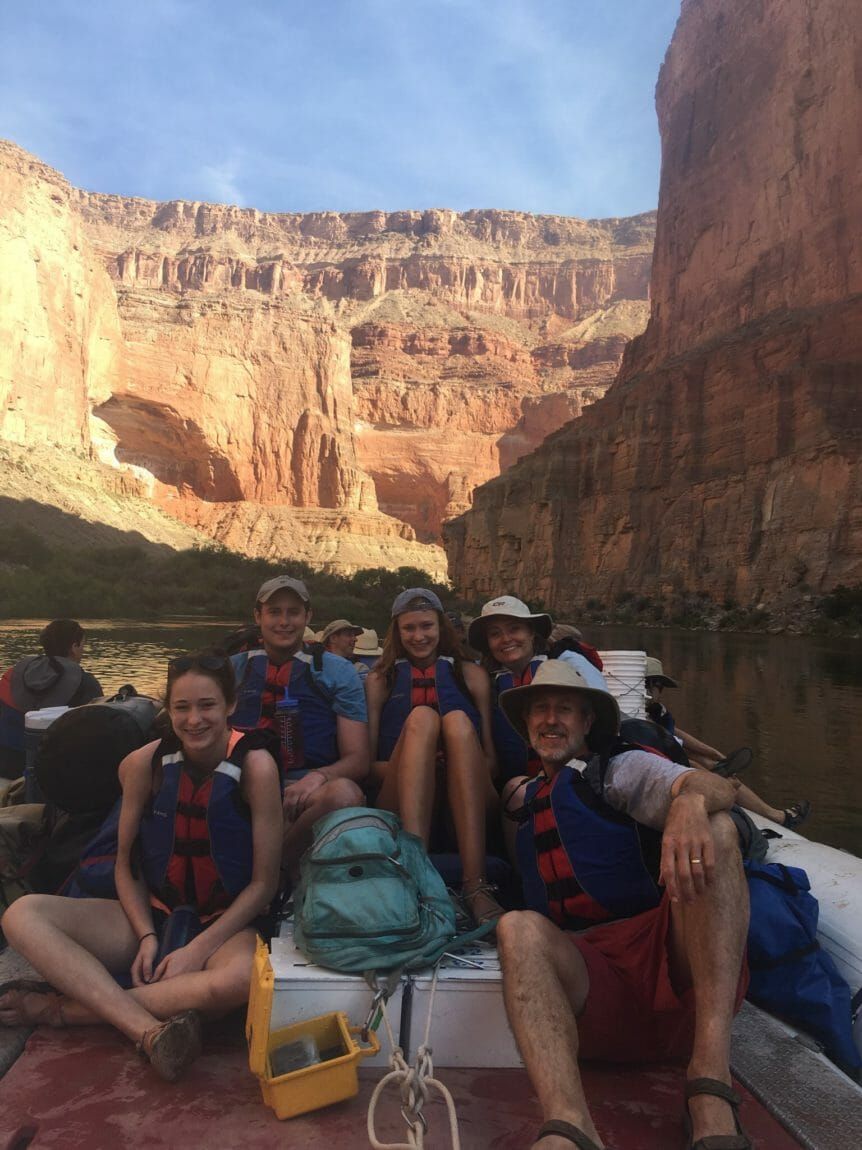 A group of people are sitting on a boat in a canyon.