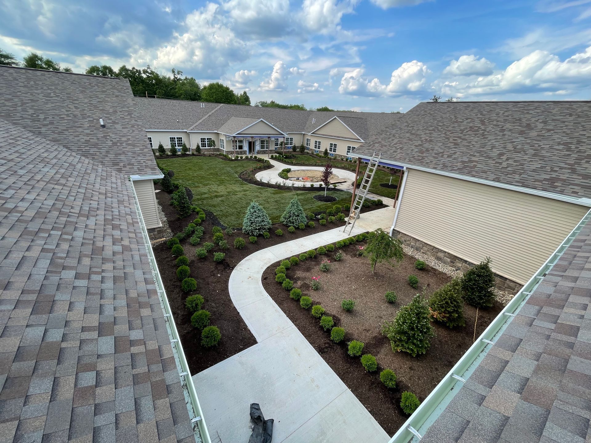 An aerial view of a house with a roof and a walkway leading to it.