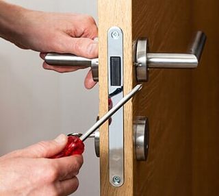 Hands repairing a door lock — residential locks in Crystal Lake, IL