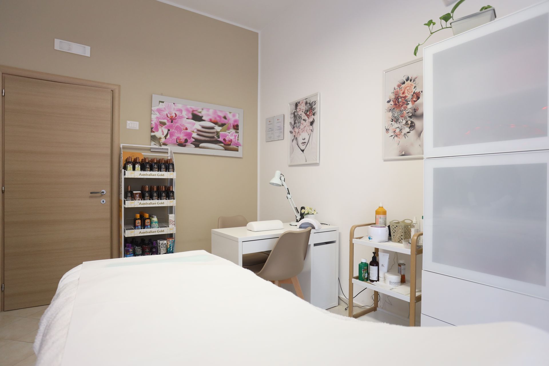 Interno di un salone per unghie con lettino per massaggi, postazione per manicure