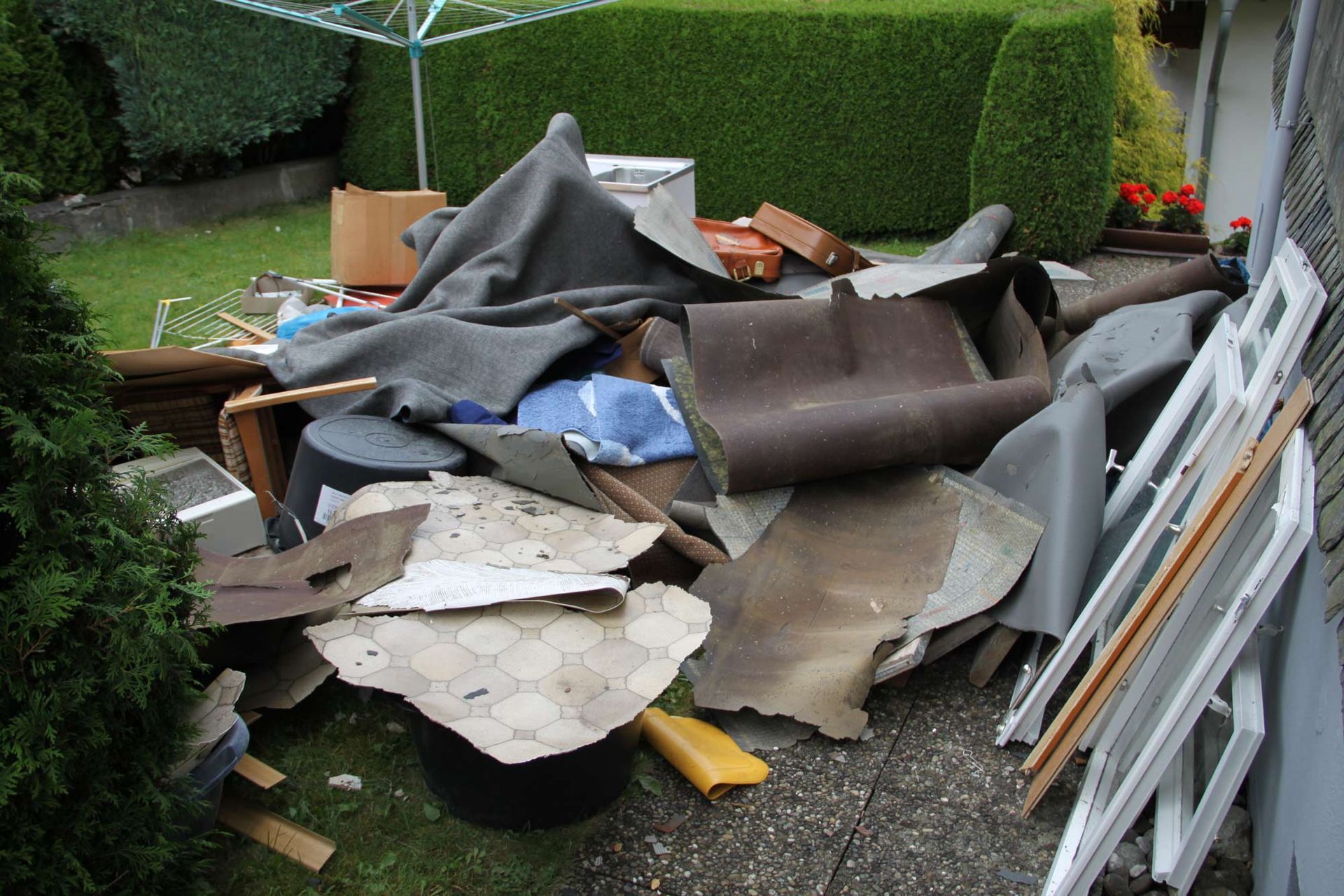 A pile of junk is sitting on the ground in front of a house