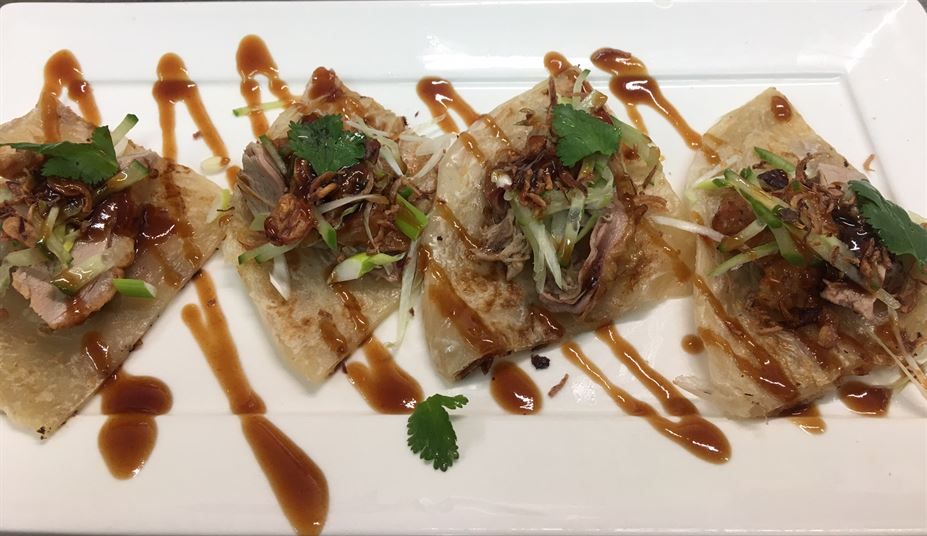 A white plate topped with a variety of food and sauces.