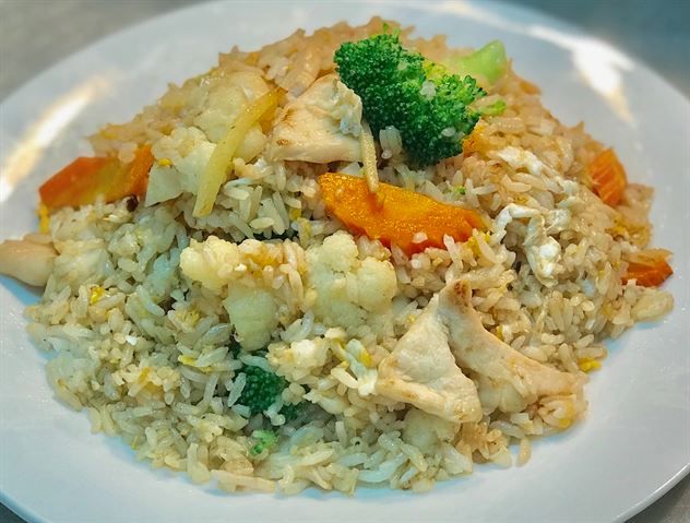 A white plate topped with rice , broccoli , carrots and chicken.