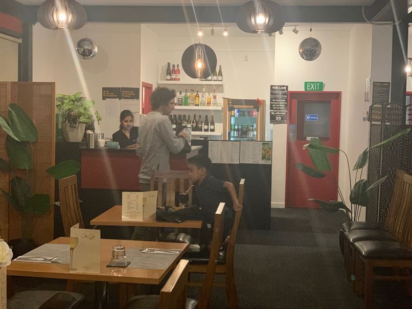A group of people are sitting at tables in a restaurant.