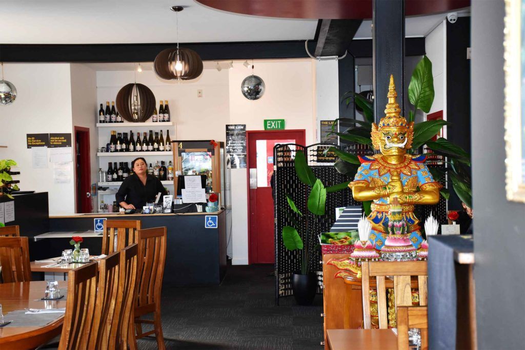 A restaurant with tables and chairs and a statue in the middle of the room.