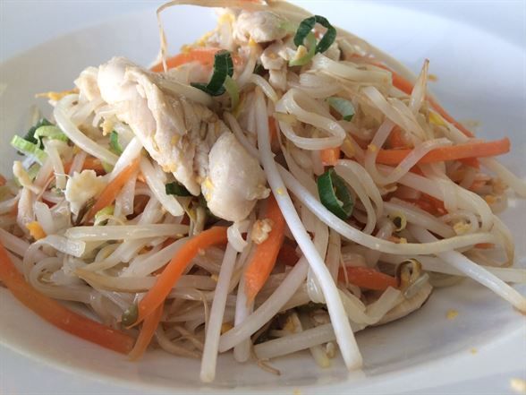 A white plate topped with noodles carrots and chicken