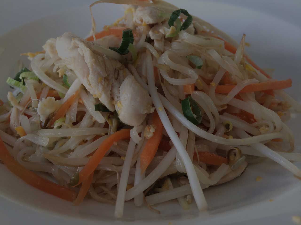 A close up of a plate of food with noodles and vegetables
