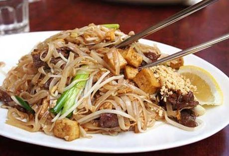 A close up of a plate of food with chopsticks on a table.