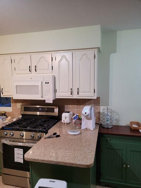 A kitchen with stainless steel appliances and white cabinets