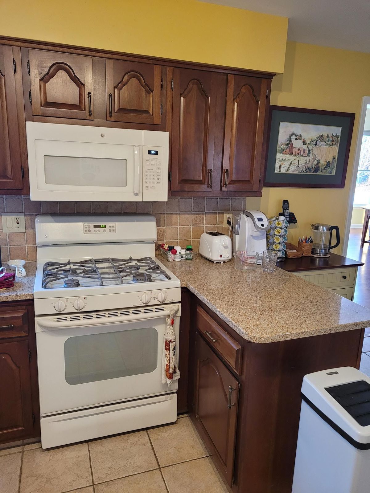 A kitchen with a stove , microwave , toaster , and sink.