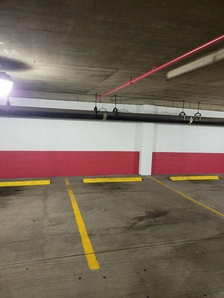 A parking garage with red and white walls and yellow lines